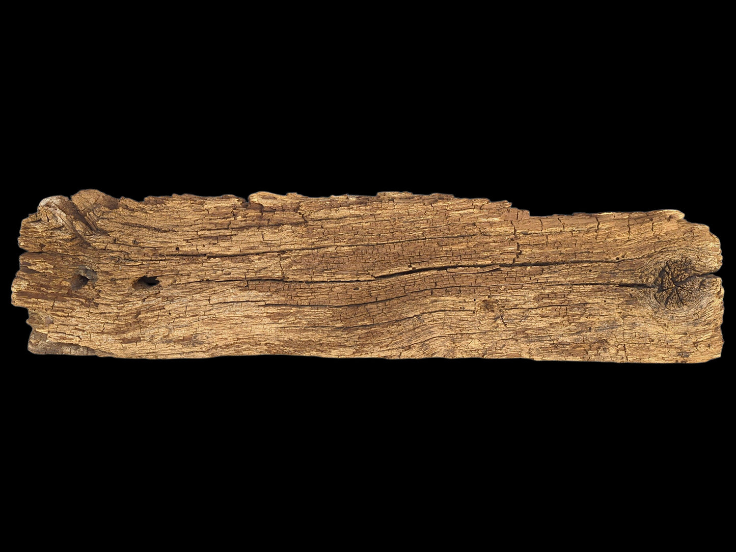 Horizontal brown wood fragment shows extensive cracks, a crumbly, flaking surface, and a knot.