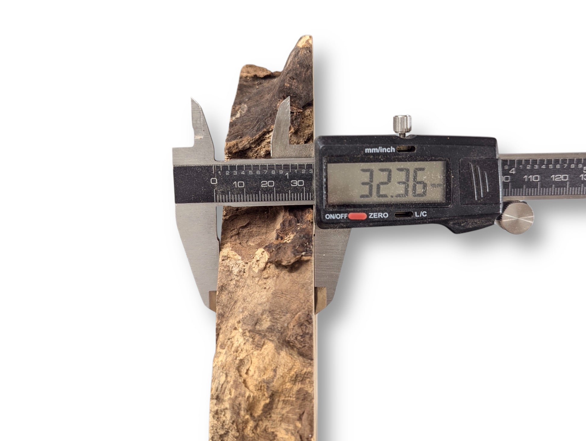 A digital caliper measures a textured, irregular black locust root wood slice at 32.36mm.