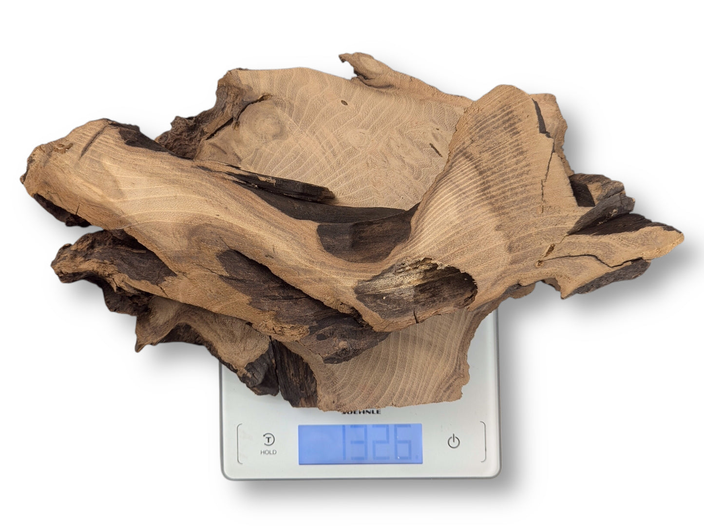 Irregular black locust root wood slice, with varied brown grain, weighs 1326 grams on a white digital scale.