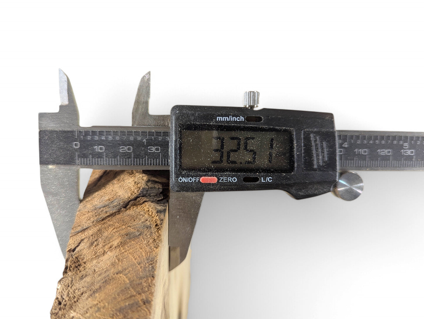 A digital caliper displays 32.51 mm measuring a brown black locust wood slice with rough bark.
