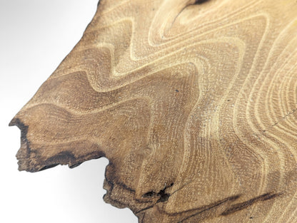 Sanded black locust wood slice displays intricate light brown wavy grain patterns and dark, irregular edges.