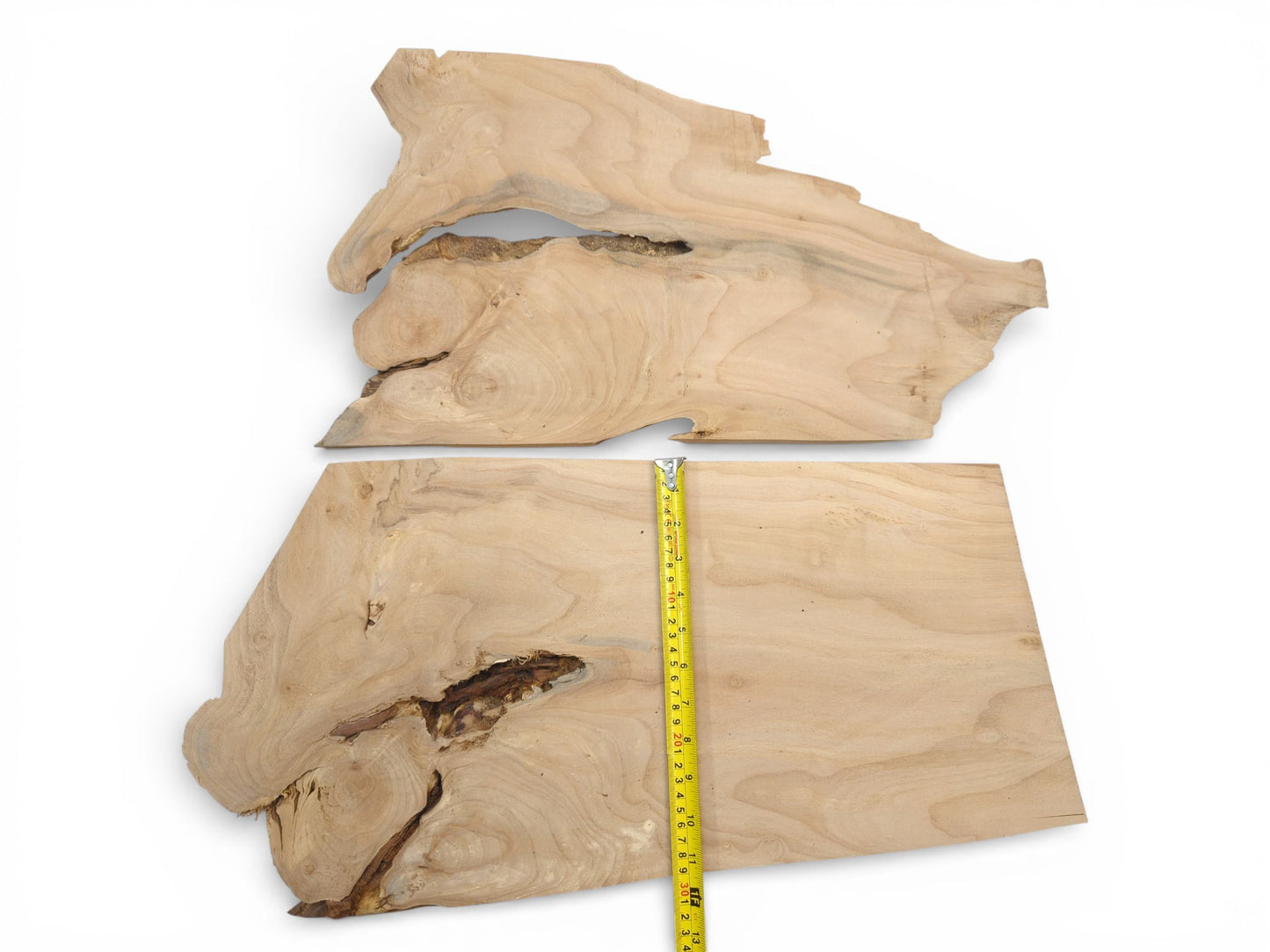 Two raw alder lumber blanks with natural voids, one positioned with a tape measure for dimensions.