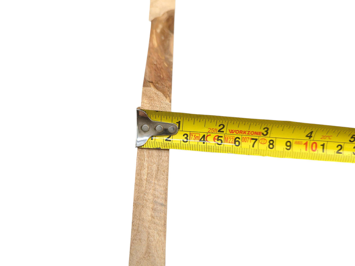 A yellow tape measure demonstrates the thickness of a raw alder lumber slab against a white background.