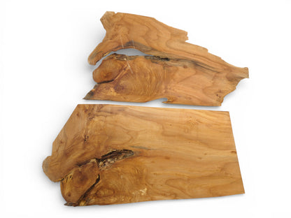 An overhead view of two differently shaped alder lumber blanks with complex grain and dark knots.