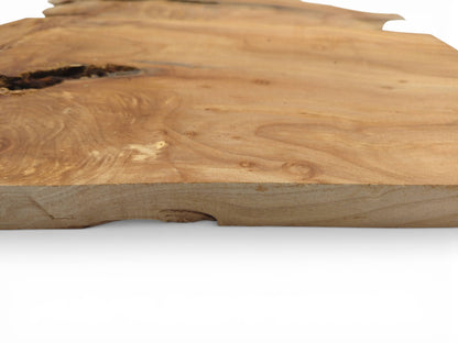 A low-angle profile of a raw alder wood slab, showing its thickness and smooth surface grain.