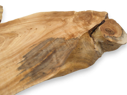 A dark, spalted grain pattern streaks across a smooth alder slab with a knotty burl.