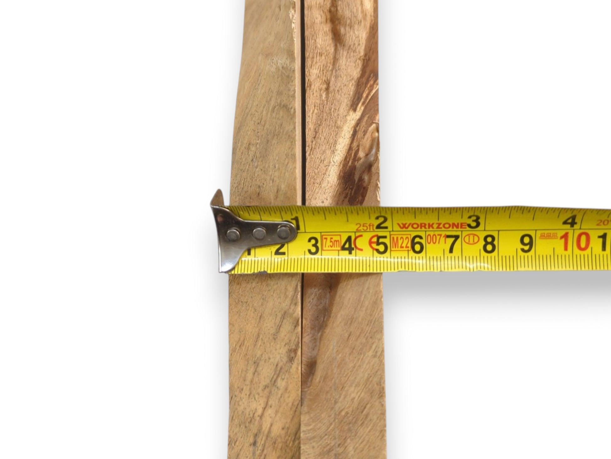A yellow tape measure spans the central seam between two light-brown, unfinished timber sections.