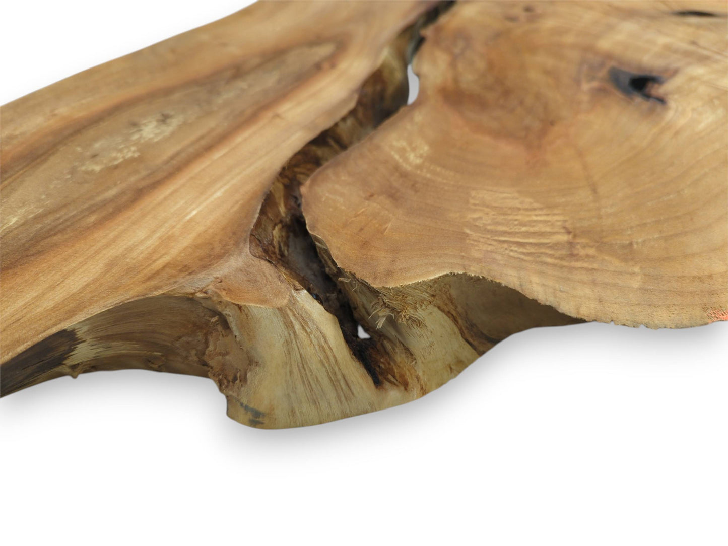 A deep, shadowy canyon cuts across a smooth timber plank with sweeping golden grain.