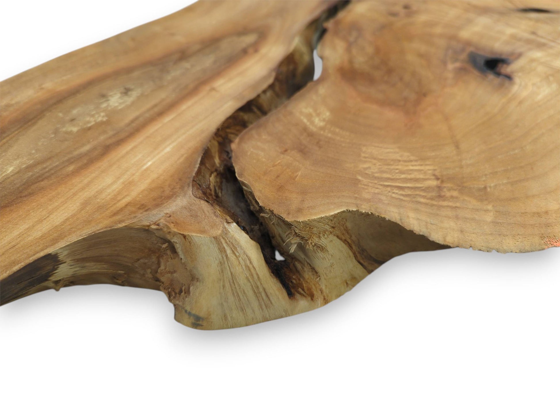 A deep, shadowy canyon cuts across a smooth timber plank with sweeping golden grain.