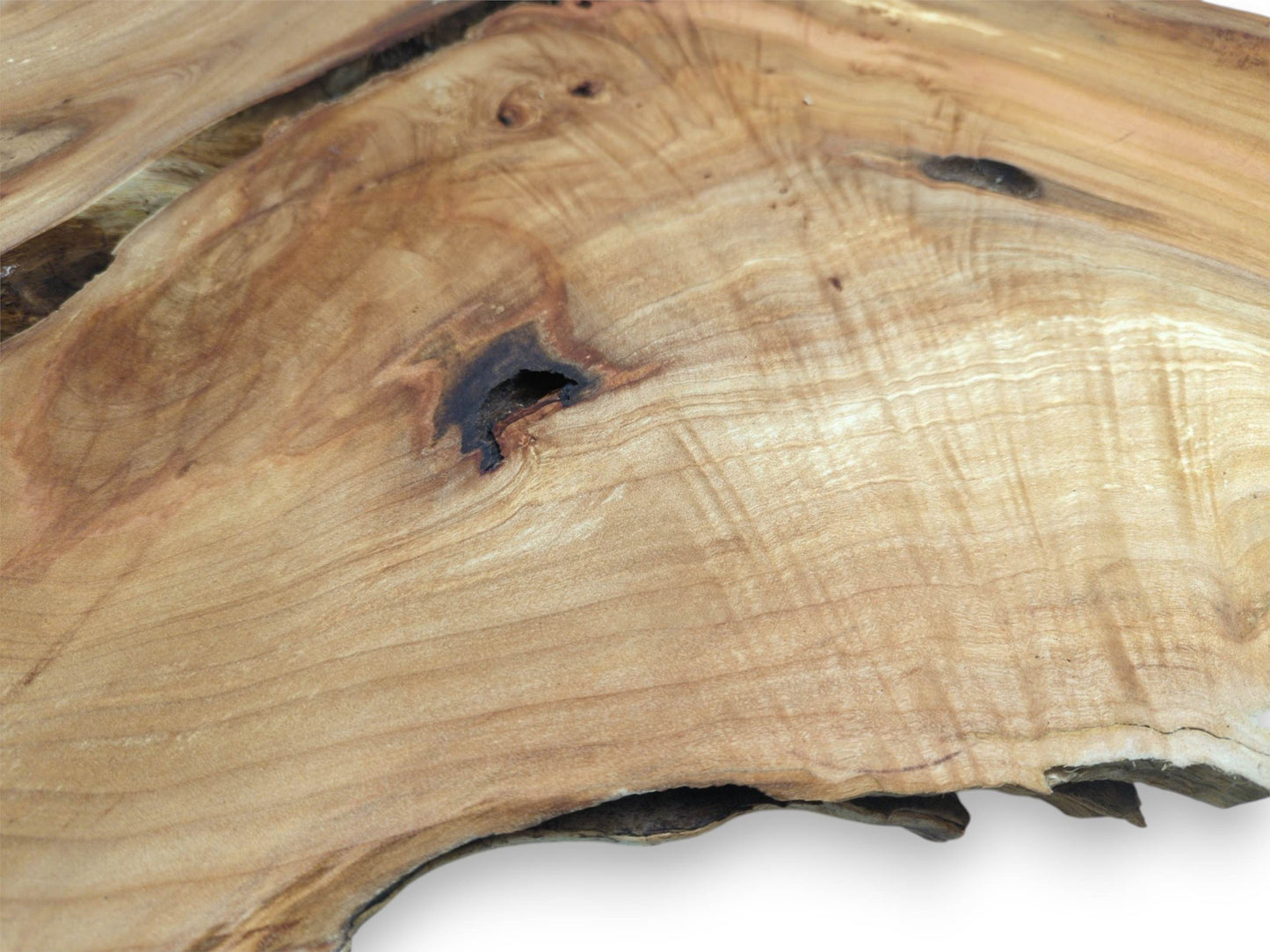 A dark, hollowed knot sits within the undulating, golden patterns of a timber cross-section.