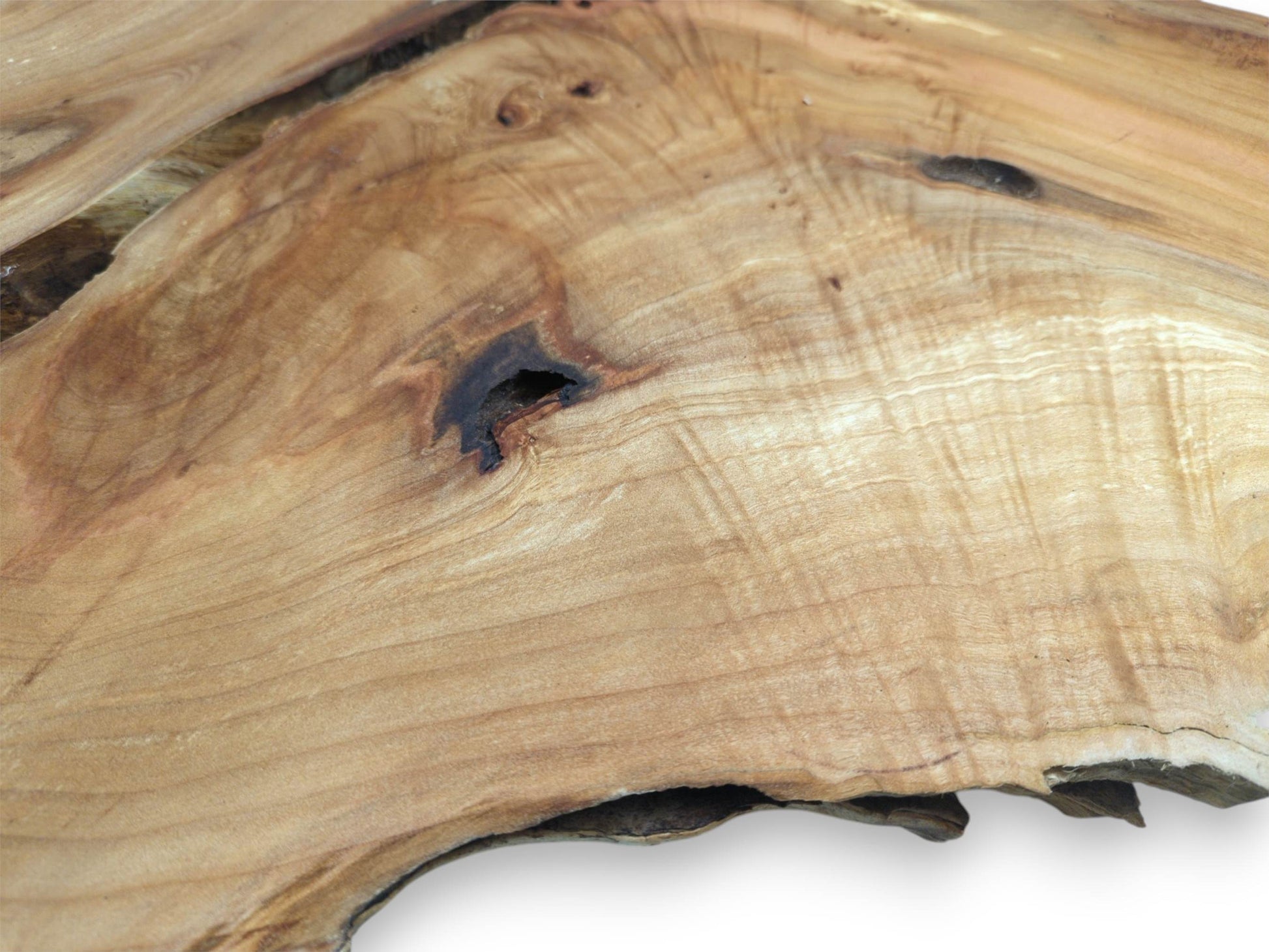 A dark, hollowed knot sits within the undulating, golden patterns of a timber cross-section.