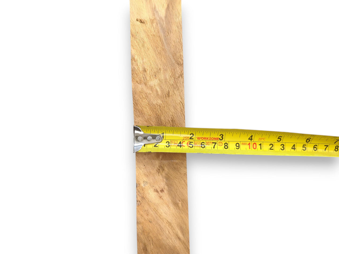 A yellow measuring tape is held horizontally across a vertical, grainy plank of lumber.