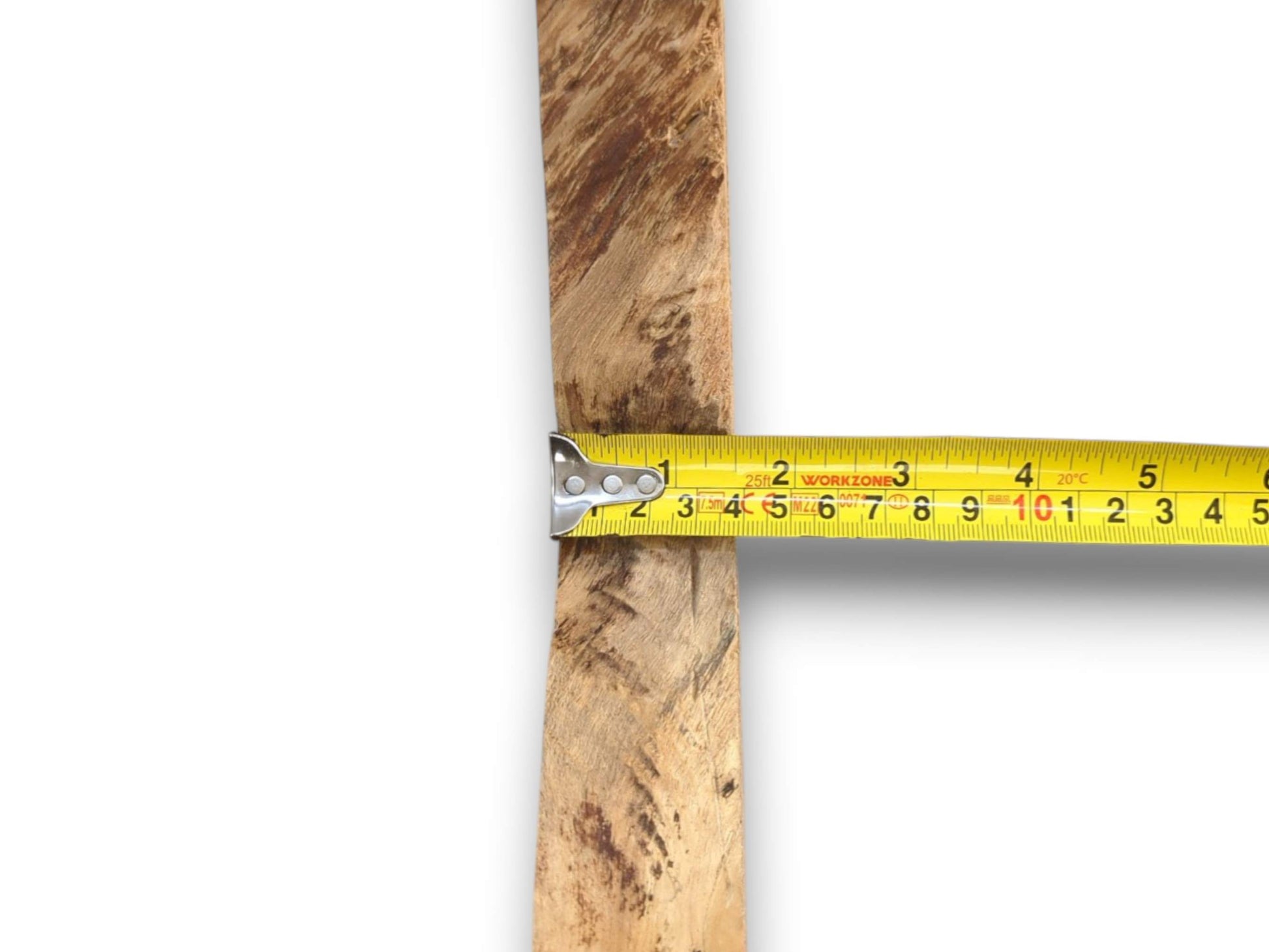 A yellow tape measure gauges the width of a narrow, rustic timber with mottled grain.