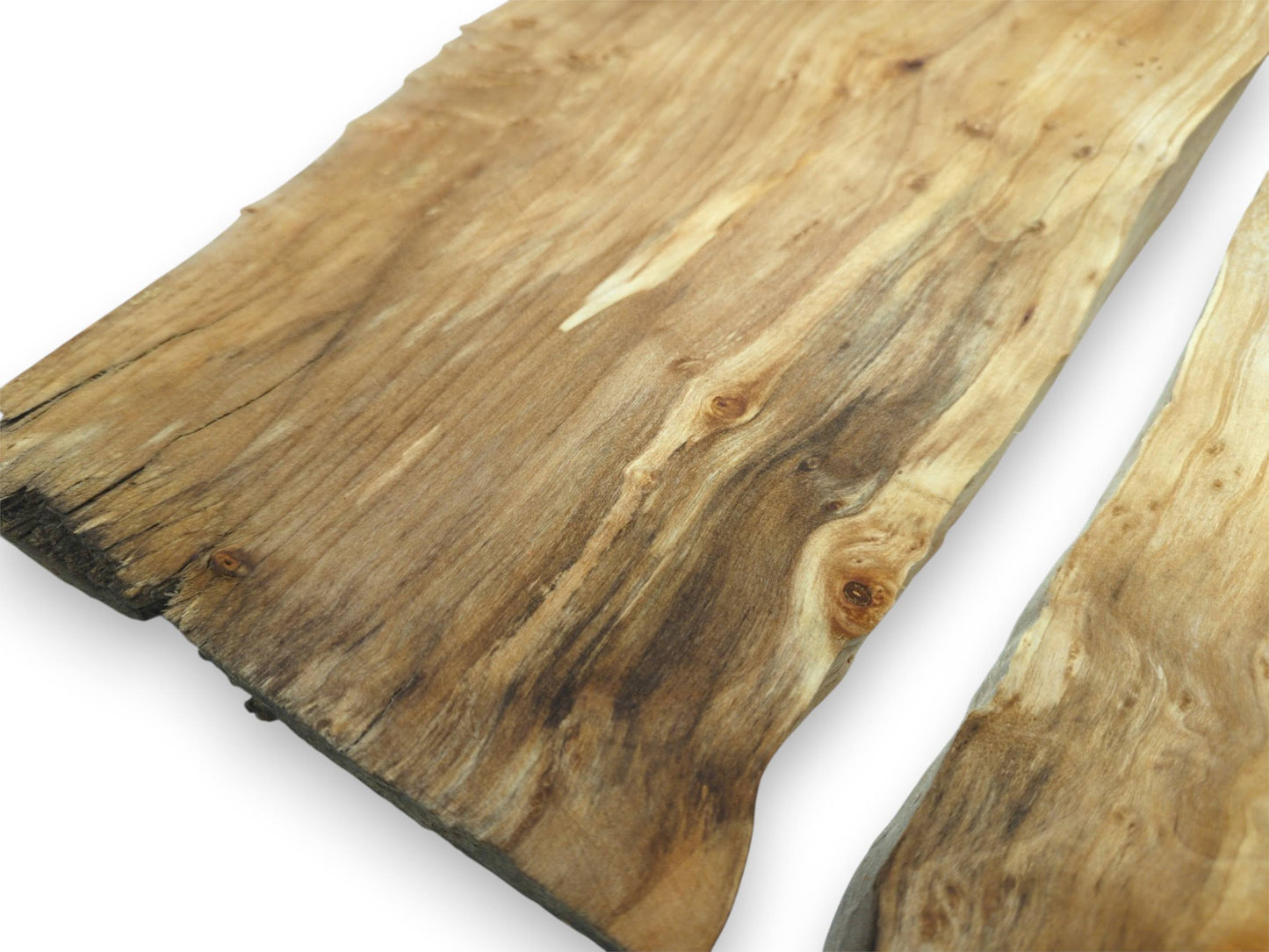 An overhead close-up captures two timber slabs with dark figuring and clustered eye-like burls.