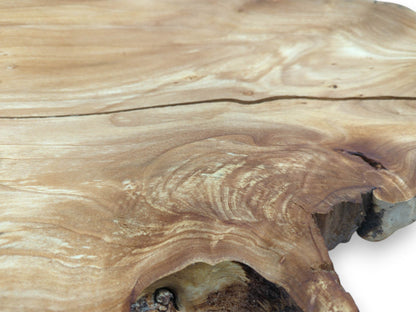 A long fissure crosses the smooth surface of a timber slab with swirling, burled grain.