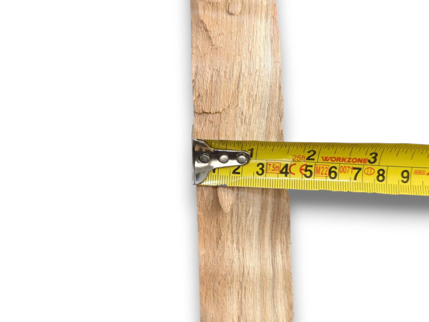 Close-up of a yellow tape measure checking the width of a rough, unfinished wood slat.