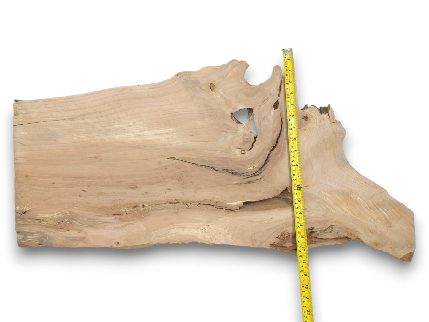 A pale lumber plank with a prominent hole and long horizontal crack is measured vertically.