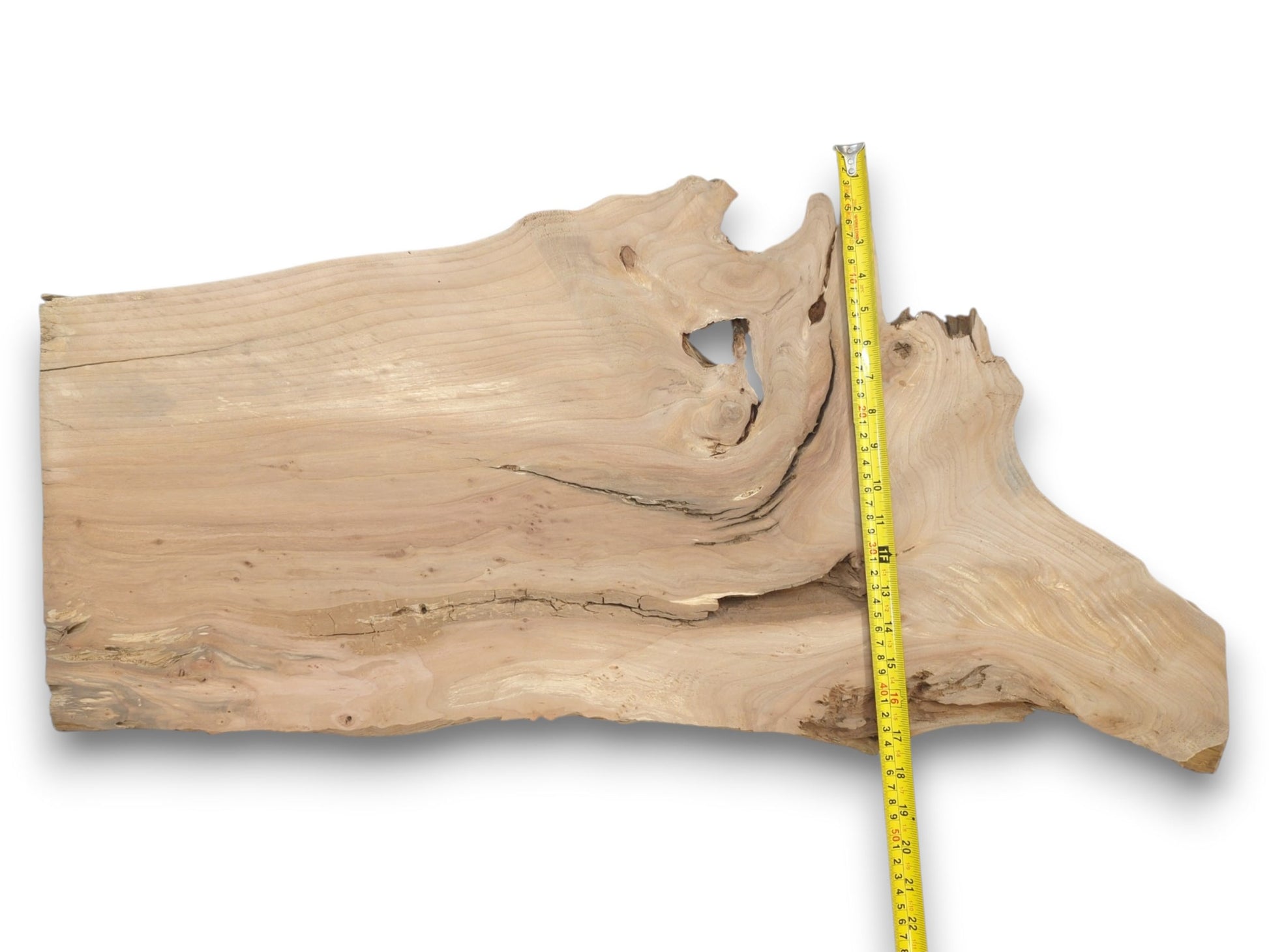 A pale lumber plank with a prominent hole and long horizontal crack is measured vertically.