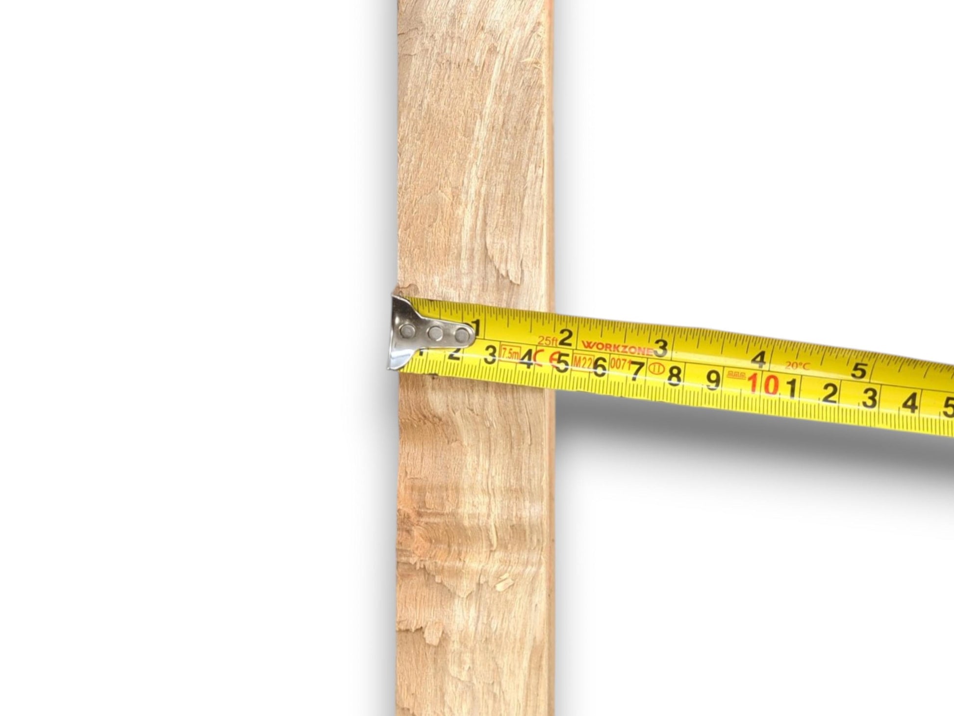 A yellow tape measure hooks onto a vertical timber plank, gauging its horizontal width.