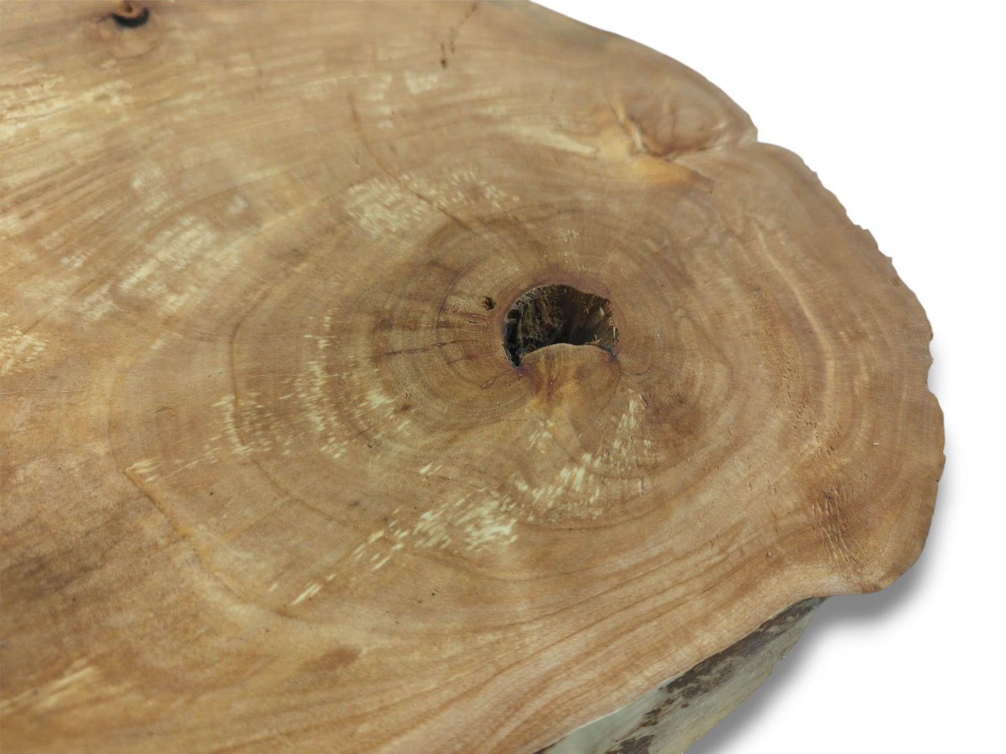 A timber round shows swirling grain and pale patches radiating from a dark central hollow.