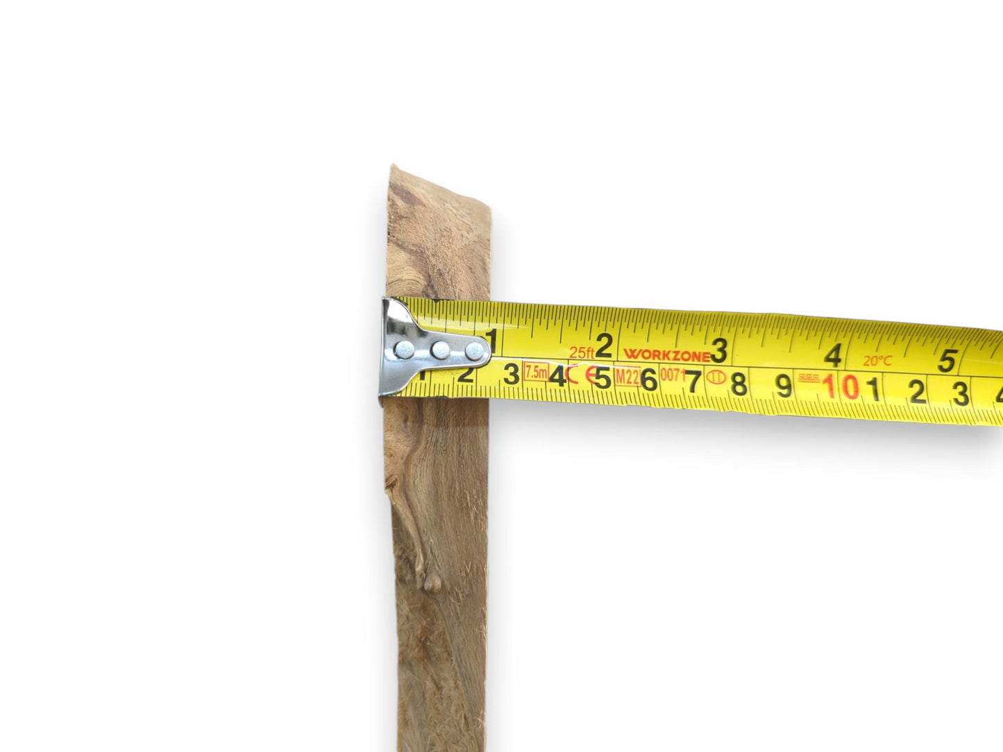 A yellow measuring tape held against a light brown alder wood slab with a live edge.