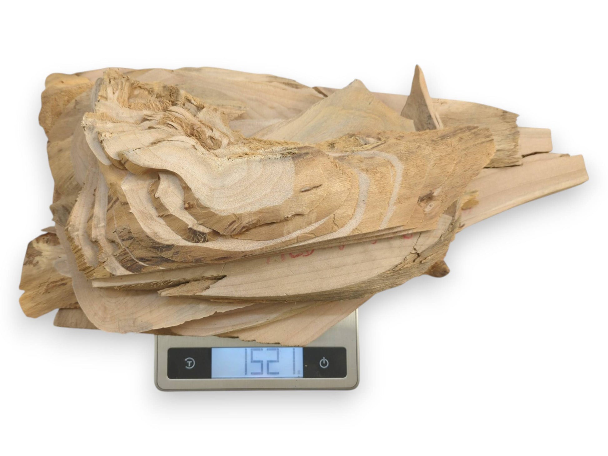 A pile of light-colored alder wood pieces with natural edges on a digital scale.