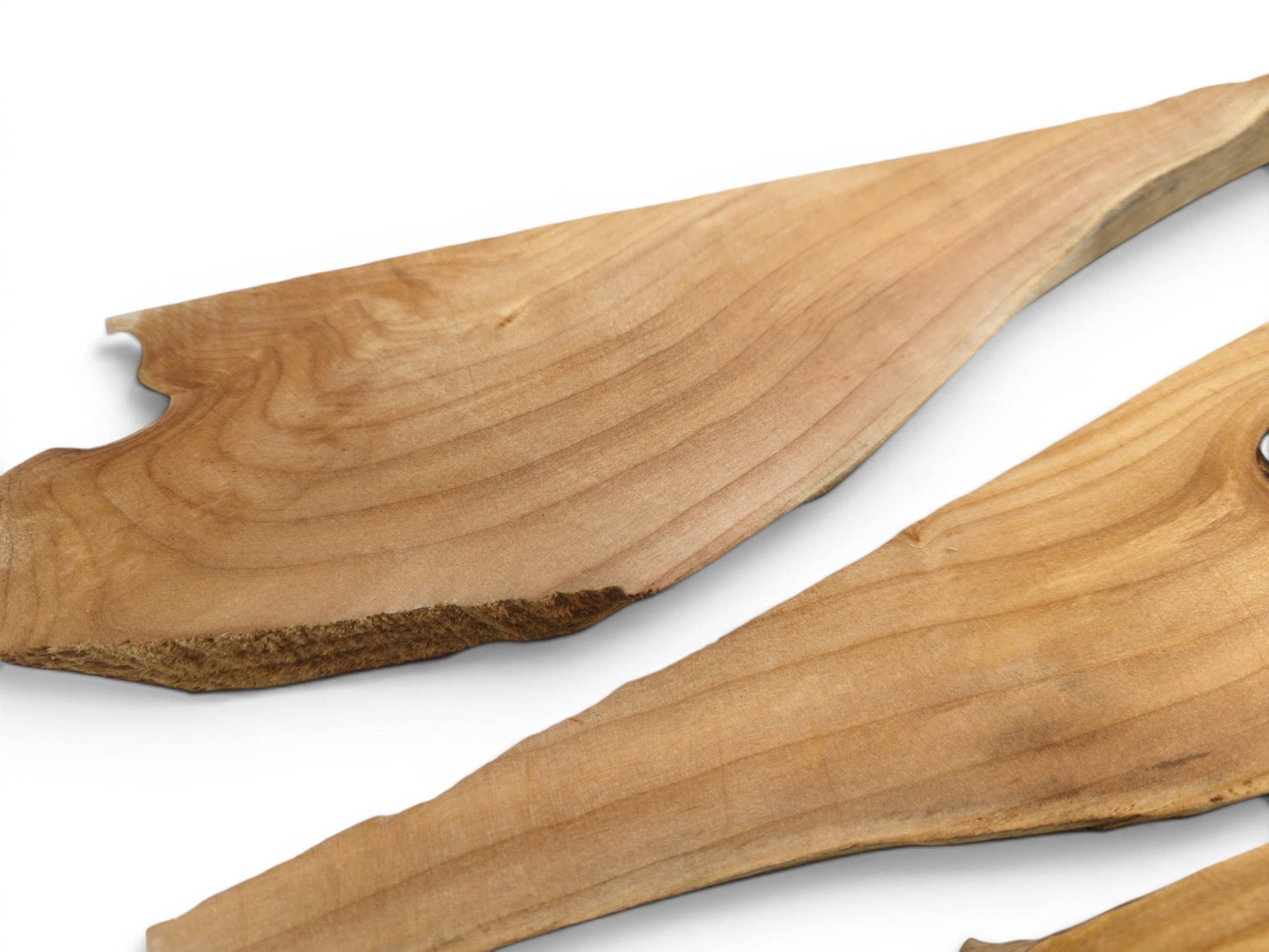 Two light brown alder wood pieces with natural wavy edges and visible grain on white.