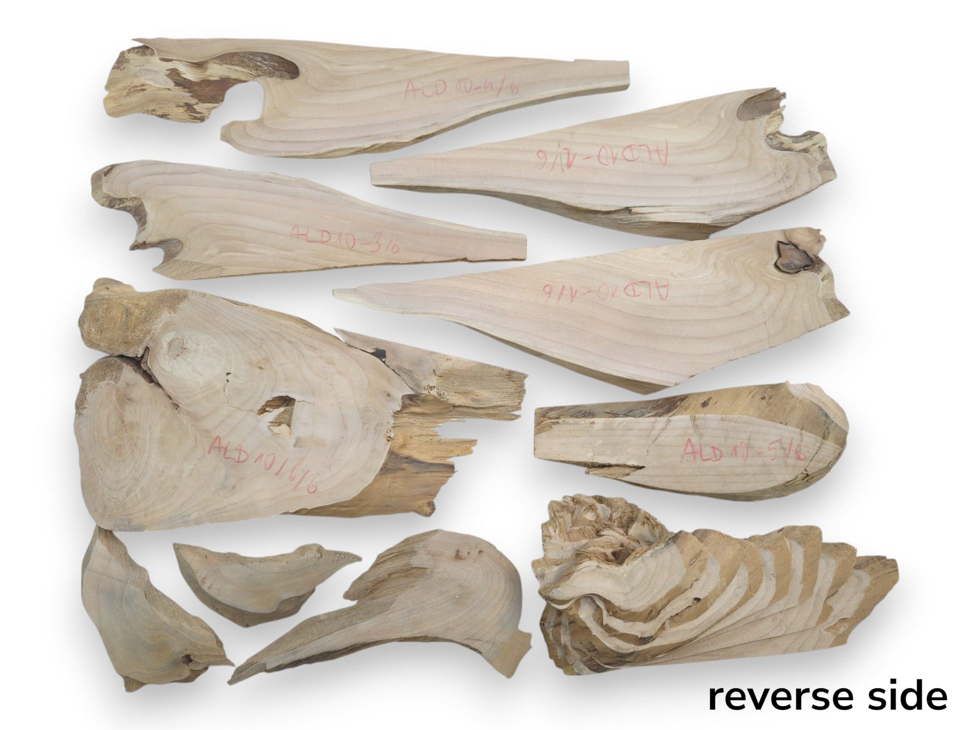 A collection of light-colored alder wood pieces with natural edges and visible grain patterns.