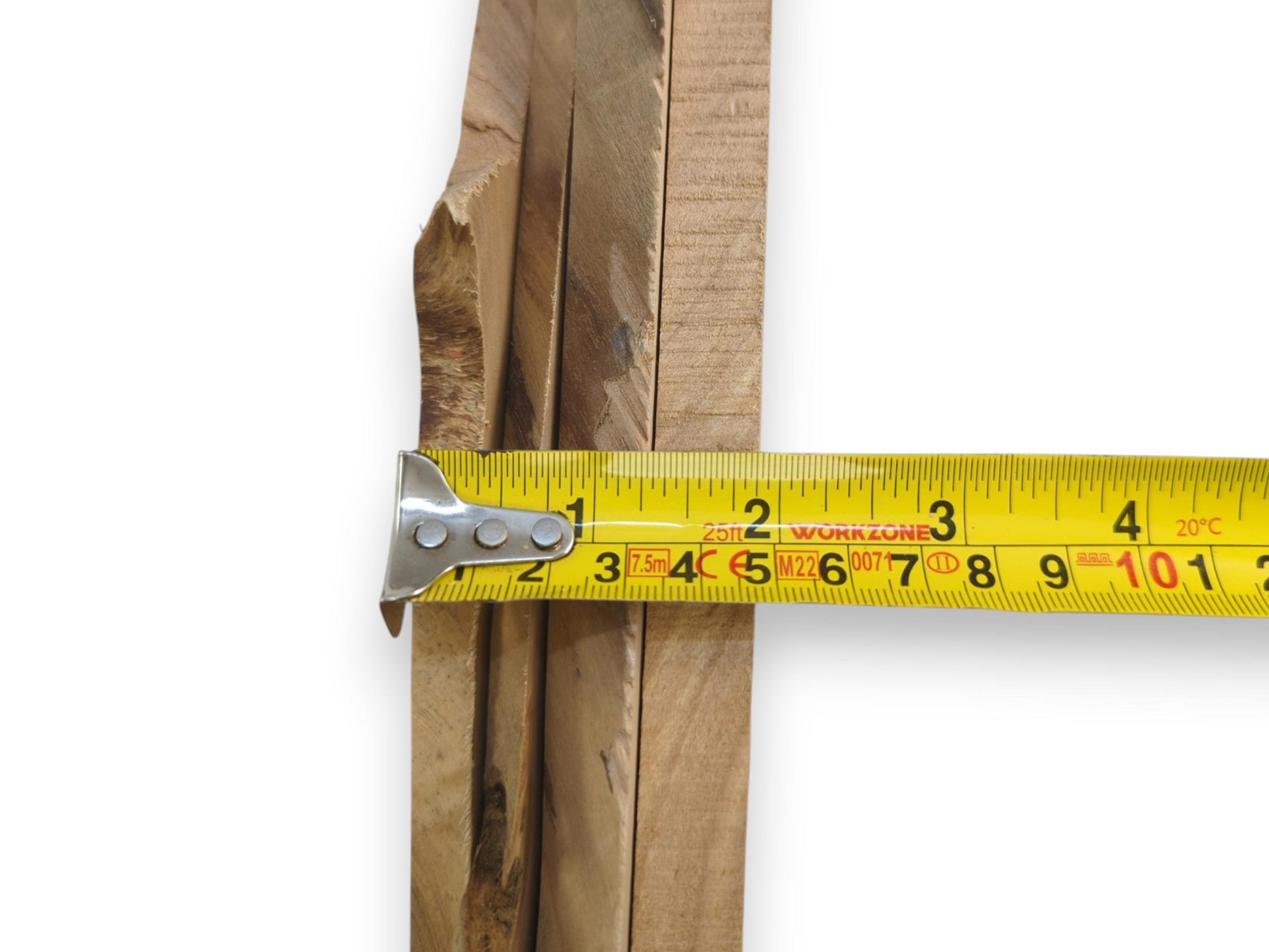 A yellow measuring tape across several thin, light brown alder wood slices with natural edges.