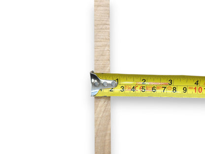 A yellow measuring tape shows the width of a light brown alder wood slice.