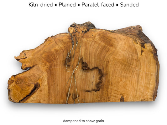 Irregular live edge wood slice showing rich grain with text indicating kiln-dried, planed, and sanded.