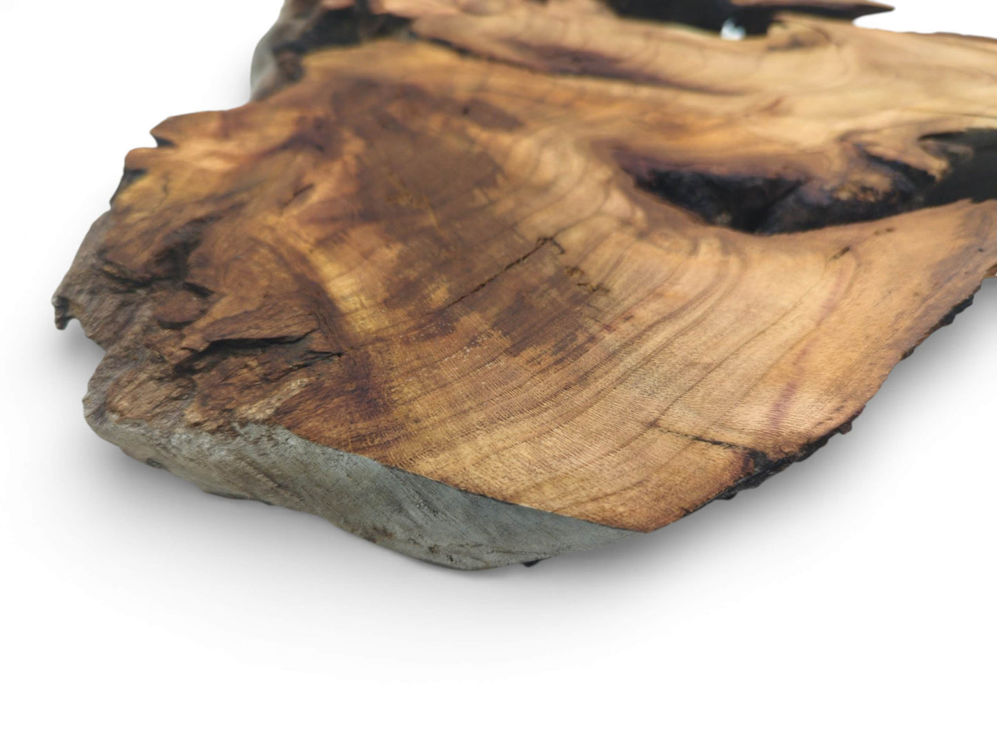 Angled close-up of a cherry wood slab corner, displaying the contoured surface grain and thick profile.