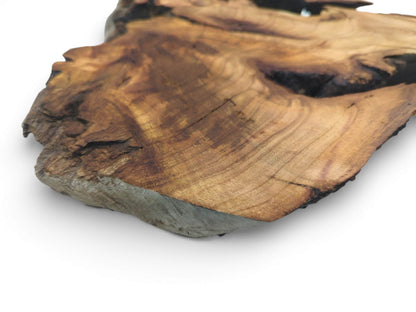 Angled close-up of a cherry wood slab corner, displaying the contoured surface grain and thick profile.