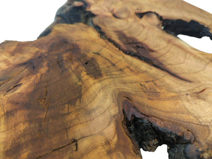 A detailed view of a cherry wood section, showing swirling grain patterns around dark inclusions.