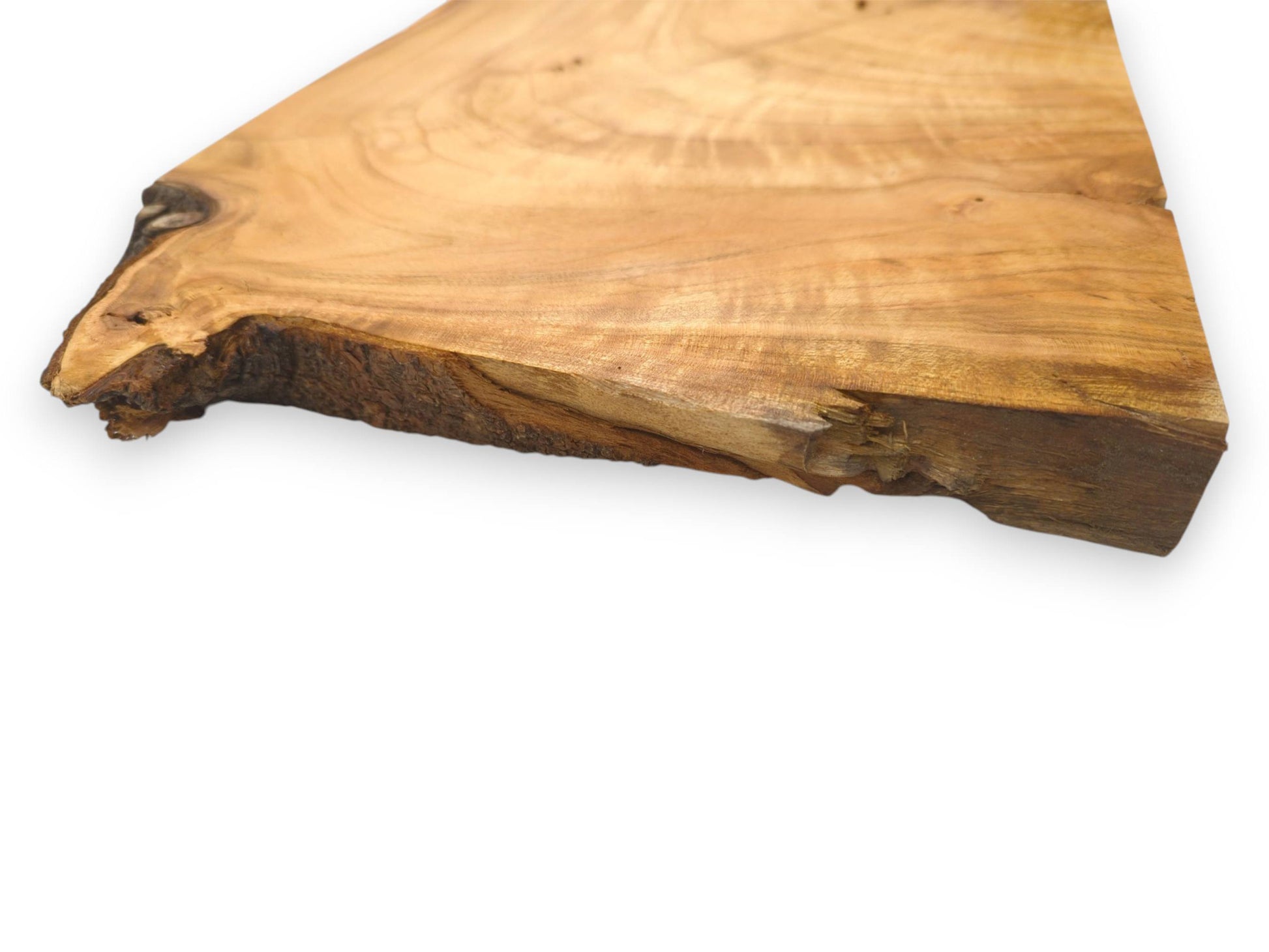 A detailed, angled view showing the wild cherry slab's thickness and its coarse, natural bark edge.