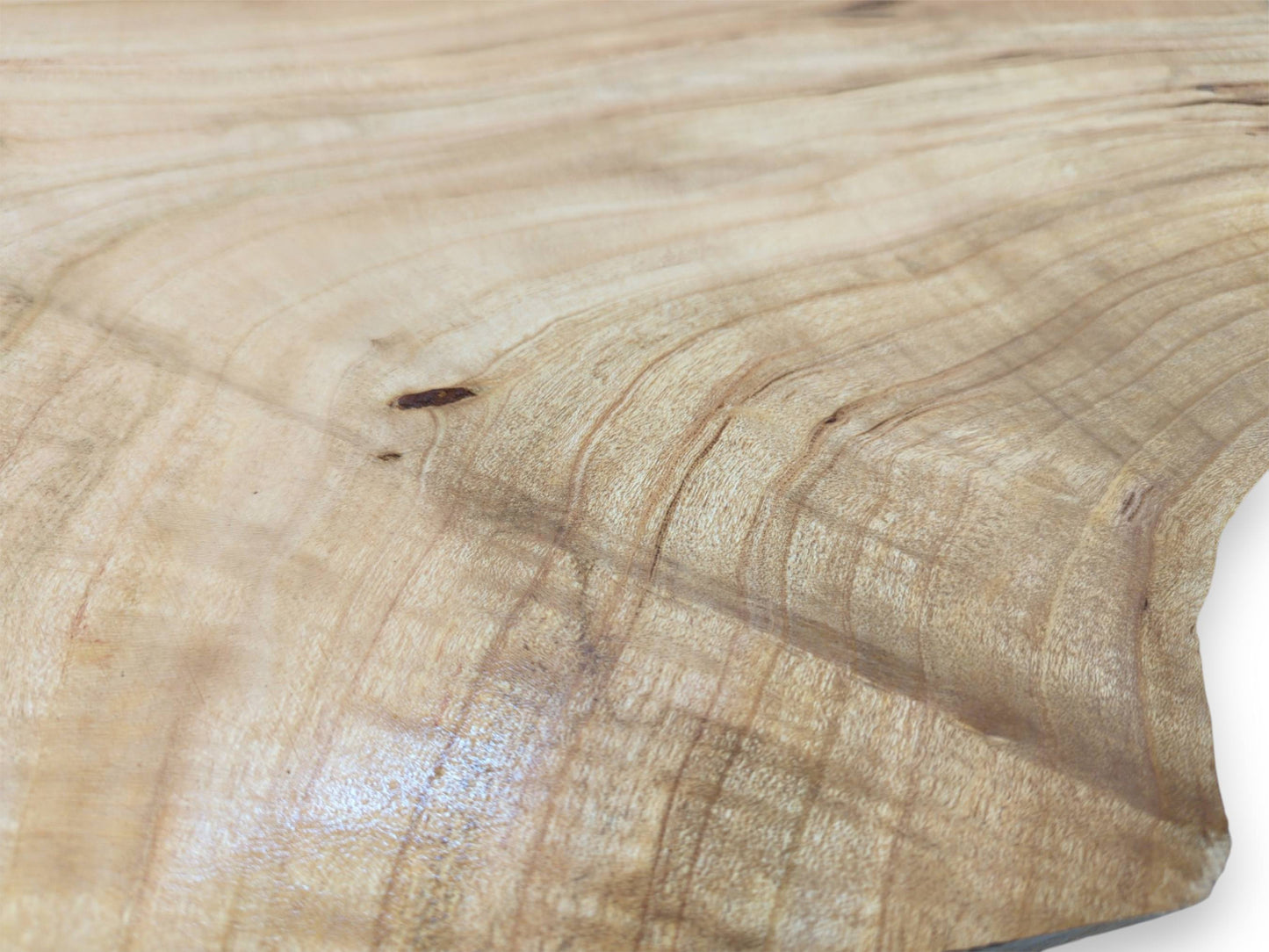 A detailed, surface-level view of a pale cherry wood plank, highlighting its fine, rippling grain pattern.