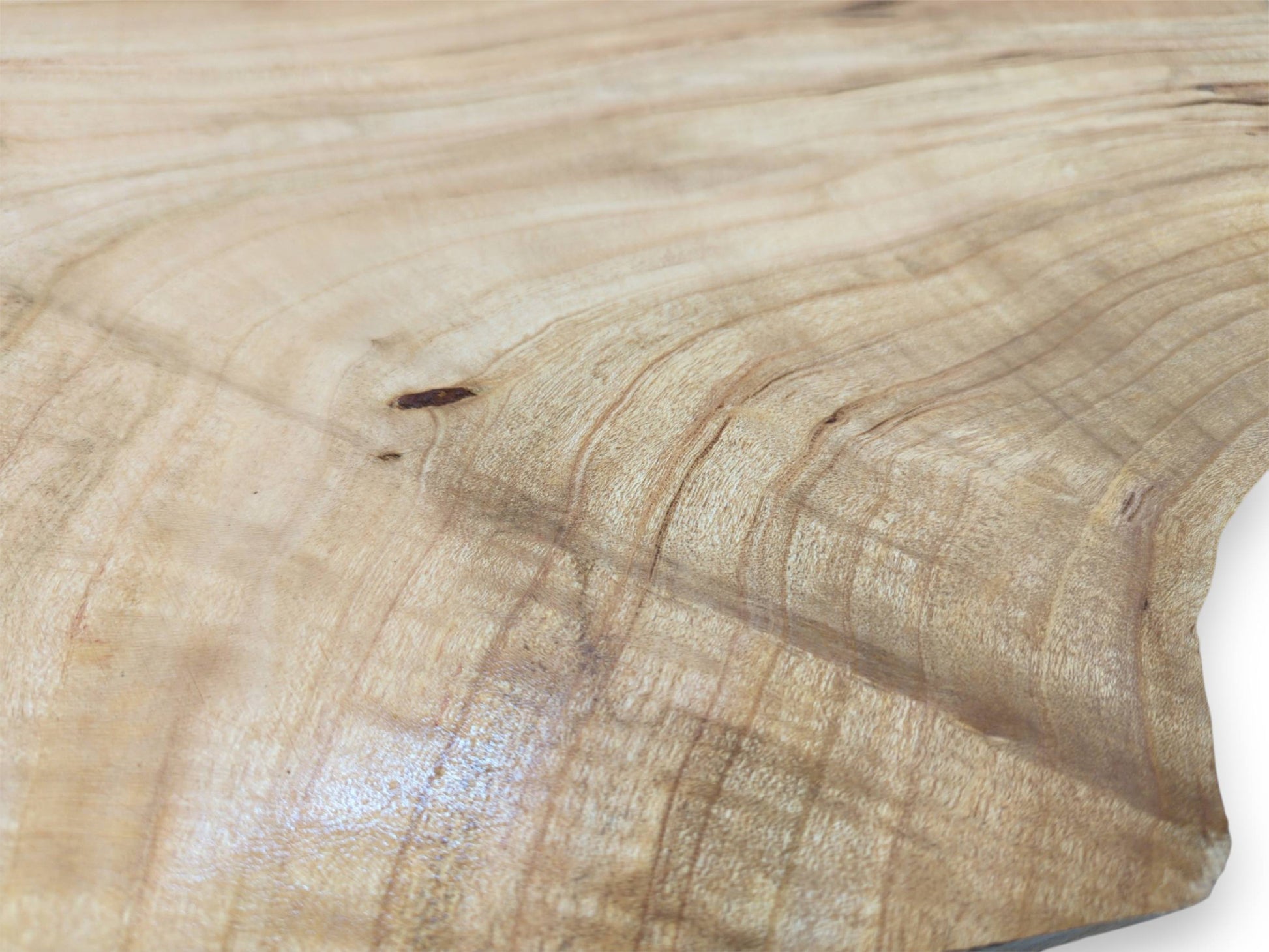 A detailed, surface-level view of a pale cherry wood plank, highlighting its fine, rippling grain pattern.