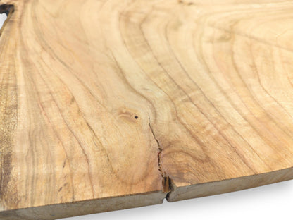 A close perspective on a cherry wood slab, featuring a small knot and a crack at the edge.