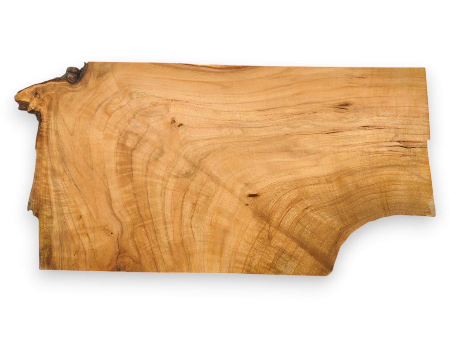 This unfinished cherry wood slab displays its full length, natural contours, and swirling wood grain.