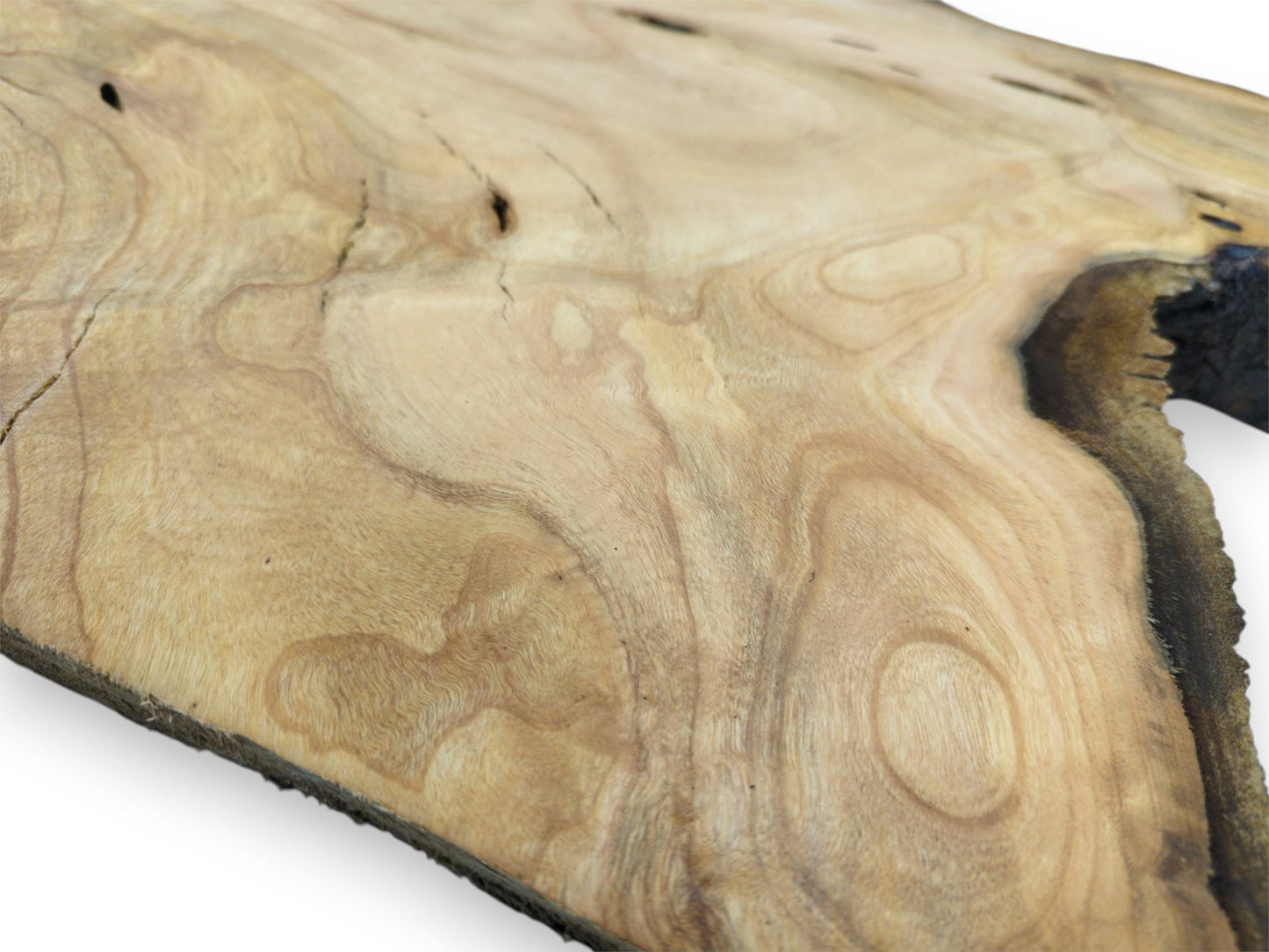 A shallow focus, angled shot across a cherry slab, revealing its complex grain and dark edge.