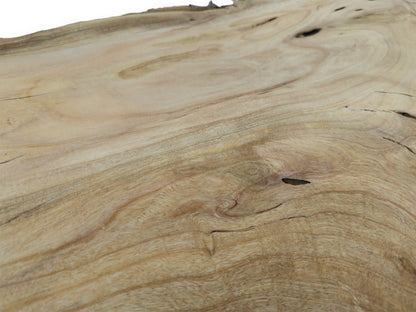 A detailed, low-angle view across a cherry wood slab showing smooth, swirling grain and knots.