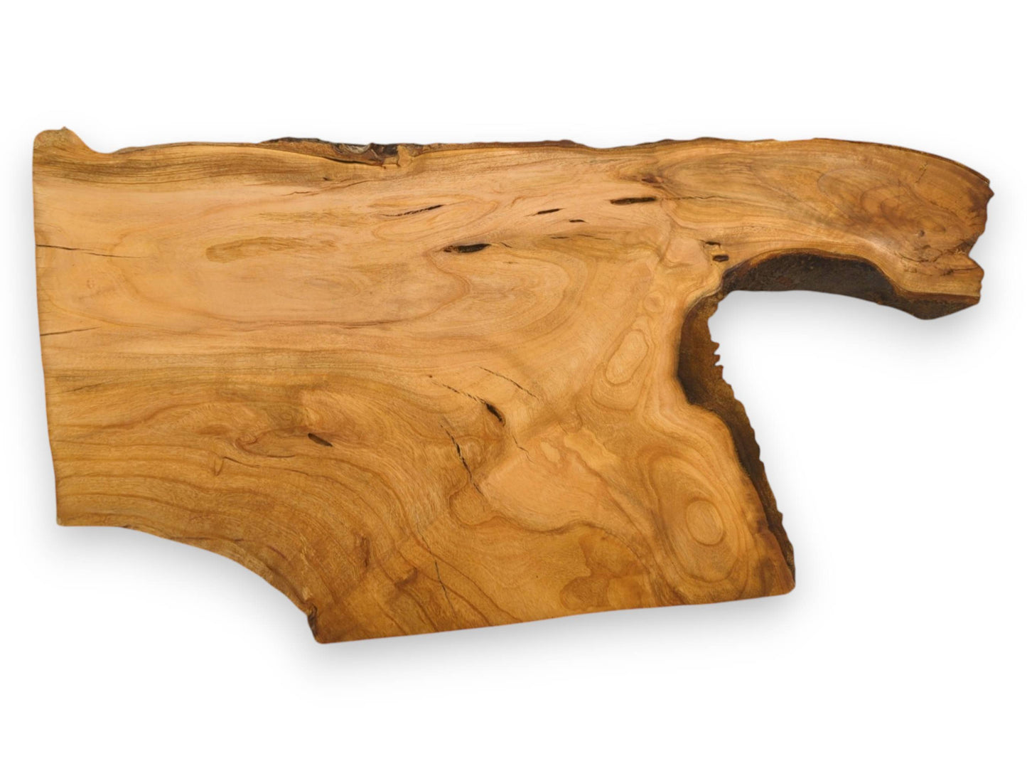 An unfinished cherry slab with wavy grain patterns and a distinctive protrusion along its natural live edge.
