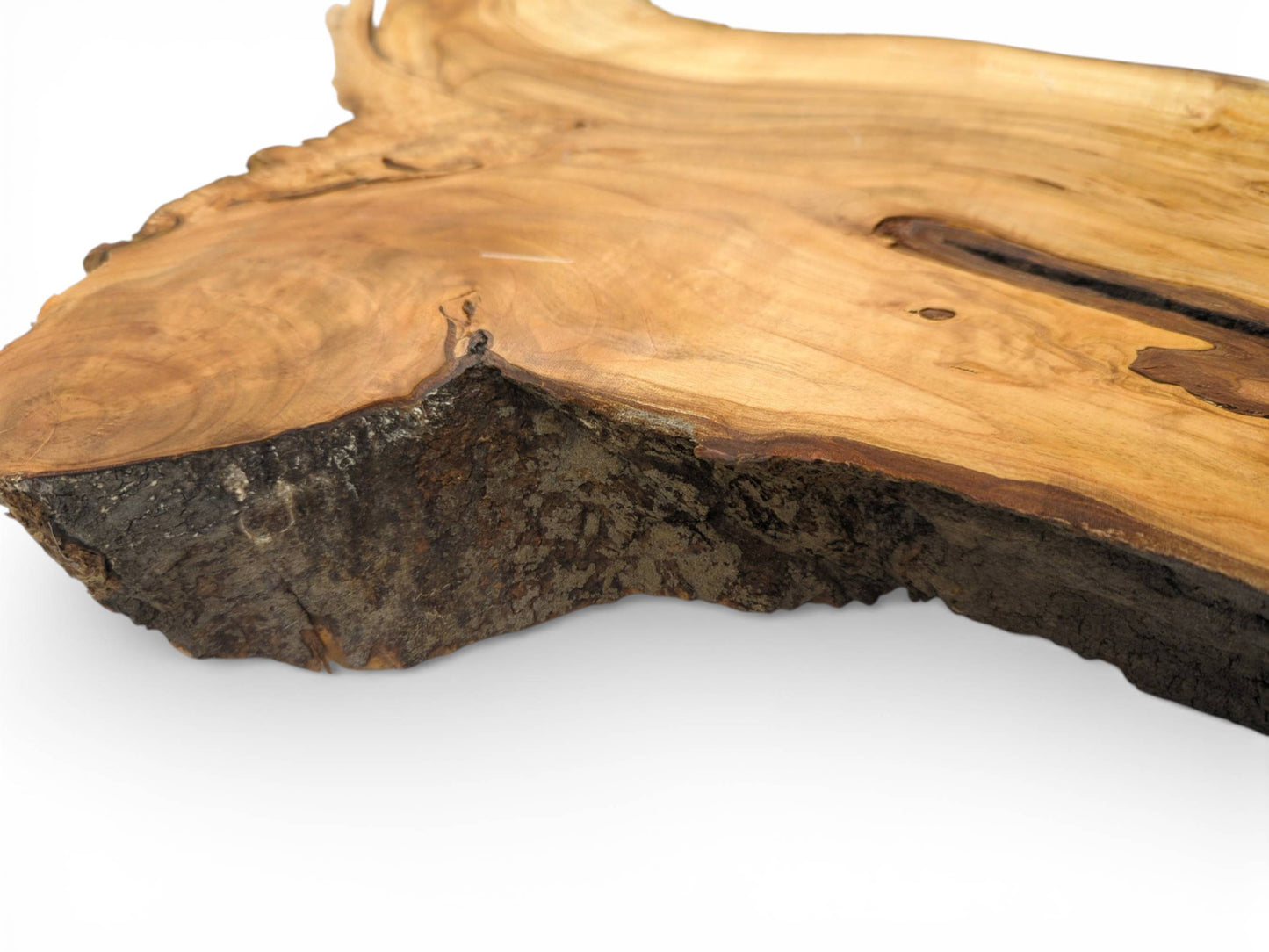Detailed, angled view of the cherry slab, emphasizing the texture of its dark, natural bark edge.