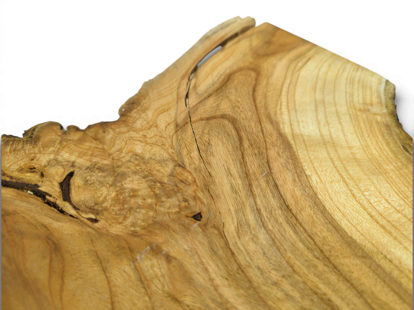 A close-up view of a cherry slab's surface, showing swirling grain, a natural knot, and a thin crack.