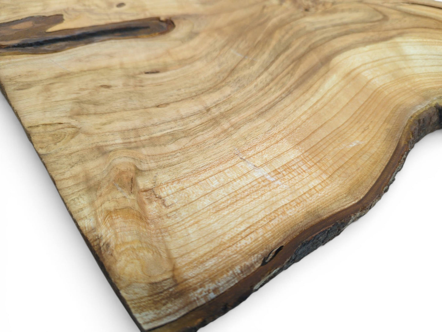 High-angle perspective on a cherry wood plank, revealing its wide, sweeping, light-colored grain patterns.