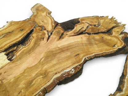 An angled perspective across a raw cherry slab, showing intricate, burled figuring along its live edge.