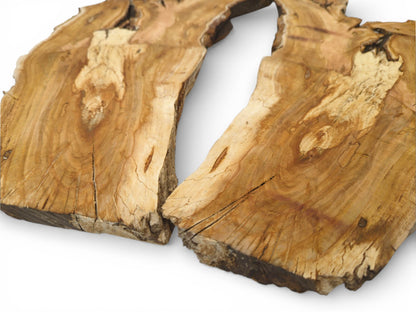 Two halves of a raw cherry wood slab showing the grained surface and deep natural cracks.