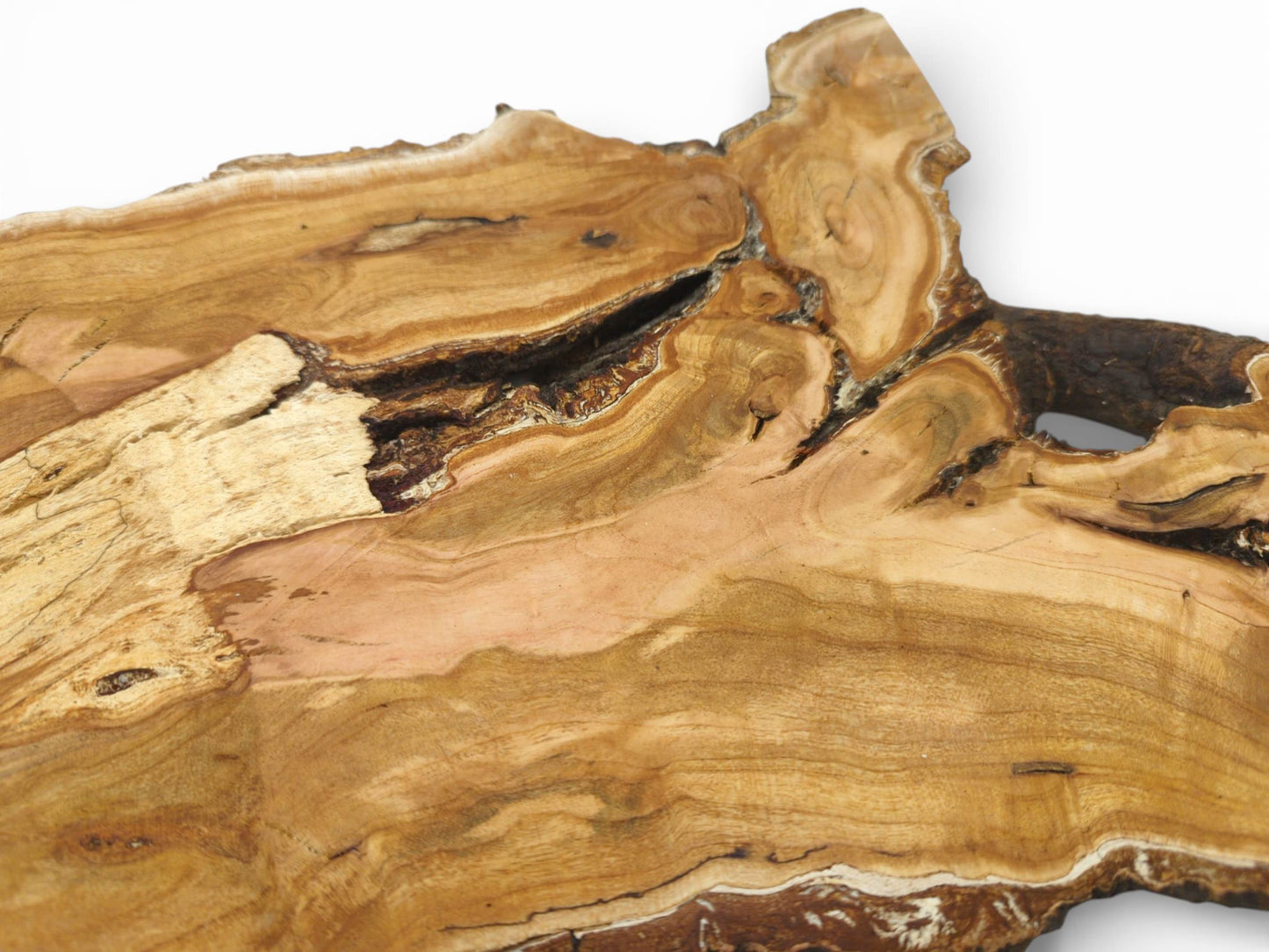 An overhead view detailing a cherry wood slab's swirling grain, pinkish hues, and large natural void.
