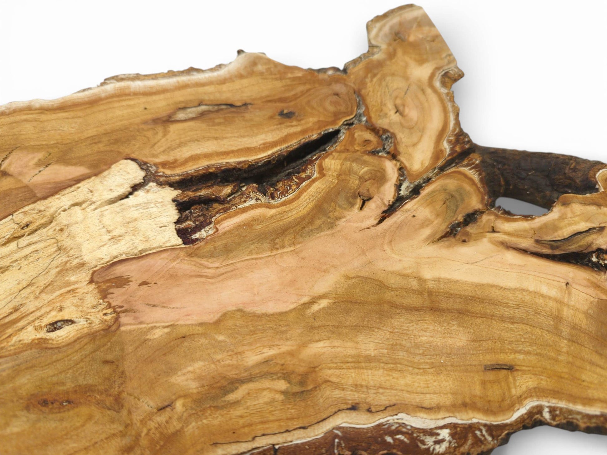 An overhead view detailing a cherry wood slab's swirling grain, pinkish hues, and large natural void.