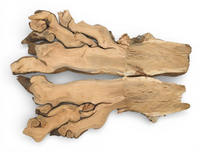 Two corresponding sections of a figured cherry root laid flat to display their symmetrical, burled shapes.